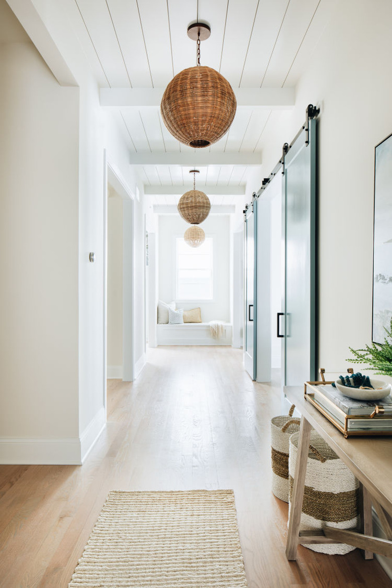 white coastal farmhouse hallway with woven pendant lights and entryway table