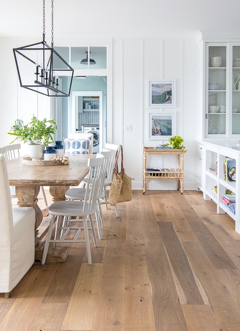 Light hardwood coastal flooring idea dining room with farmhouse table and chairs