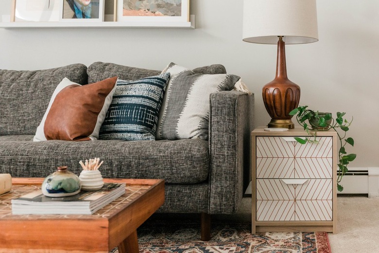 Scandinavian white-neutral nightstand with plant and lamp with gray couch