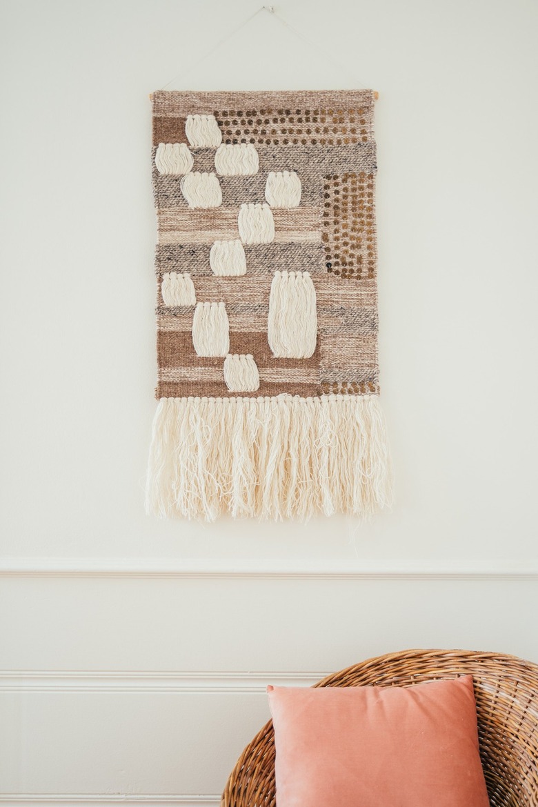 Yarn wall hanging in a boho-California style.