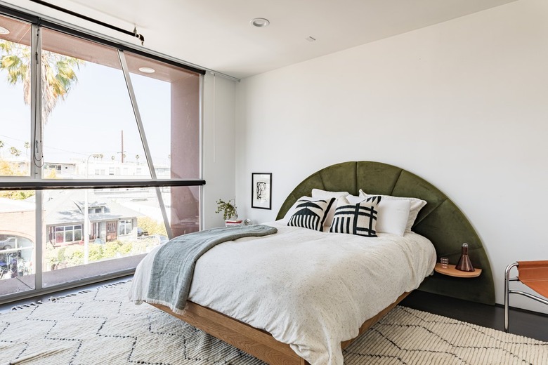 bedroom with white walls and green and brown furniture