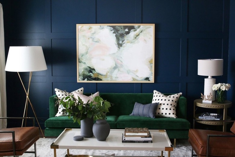 navy blue wall with emerald green velvet sofa