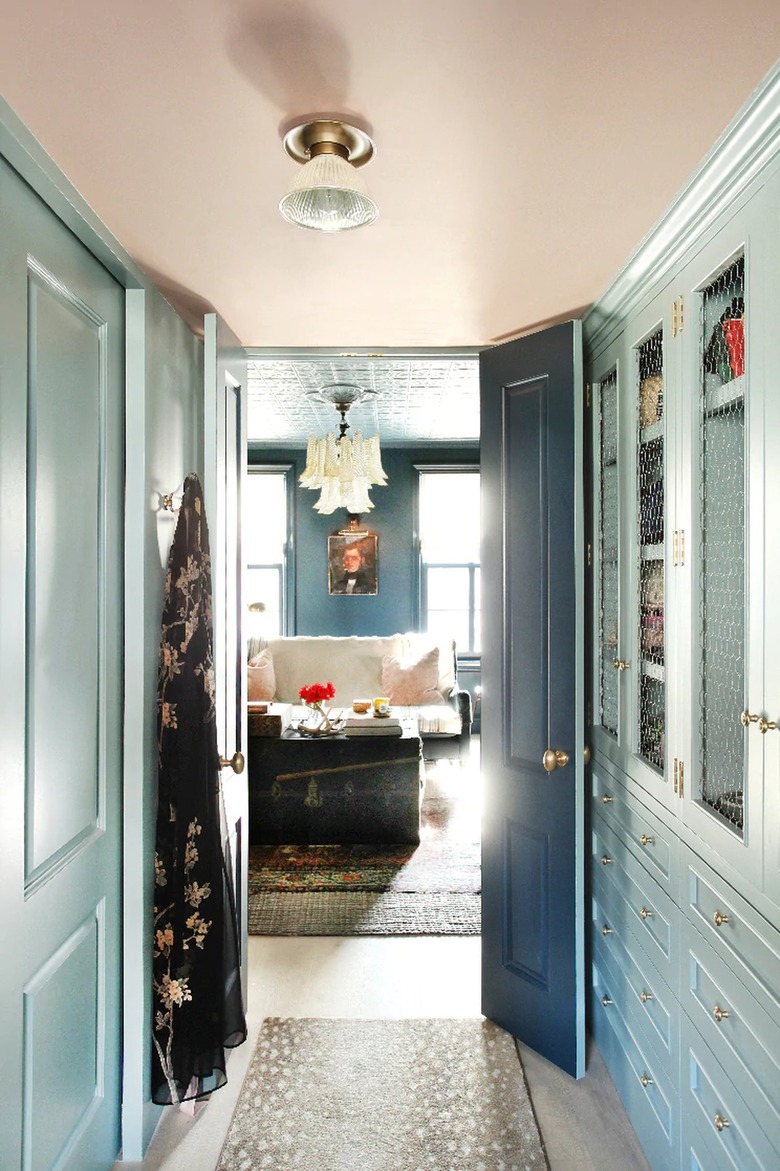 walk-in closet with seafoam green walls and peach ceiling