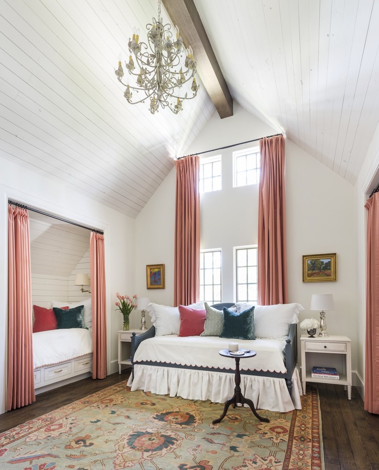 White guest bedroom with coral pink curtains