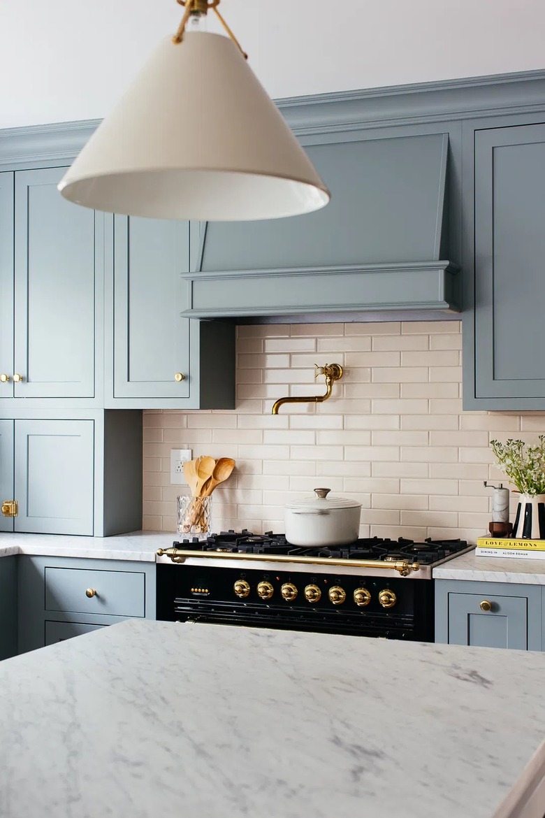 kitchen with light blue cabinets and cream tile backplash