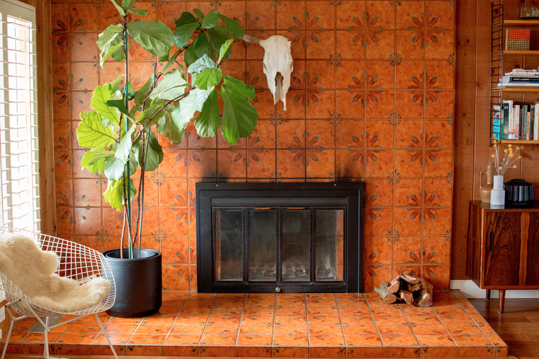 Orange tiled fireplace with large fiddle leaf fig tree