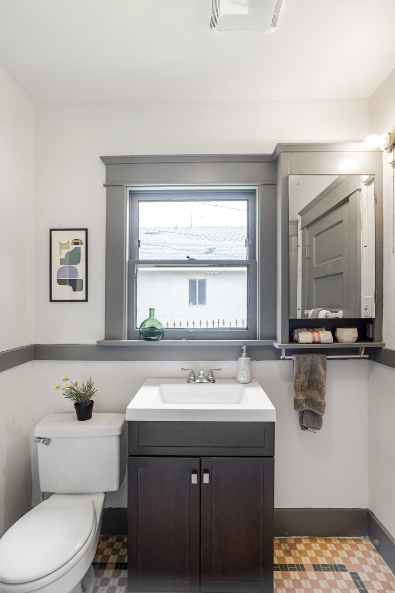 Bathroom with neutral black tile flooring, small vanity and gray accents