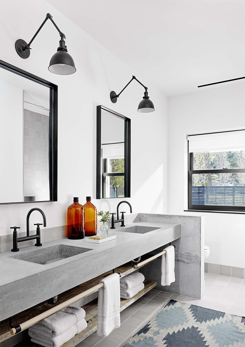 industrial bathroom with concrete countertop and black fixtures