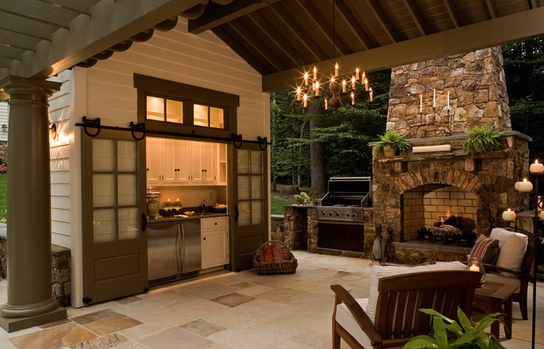 Double Contemporary Barn Doors, outdoor kitchen and fireplace, outdoor patio, arm chairs.