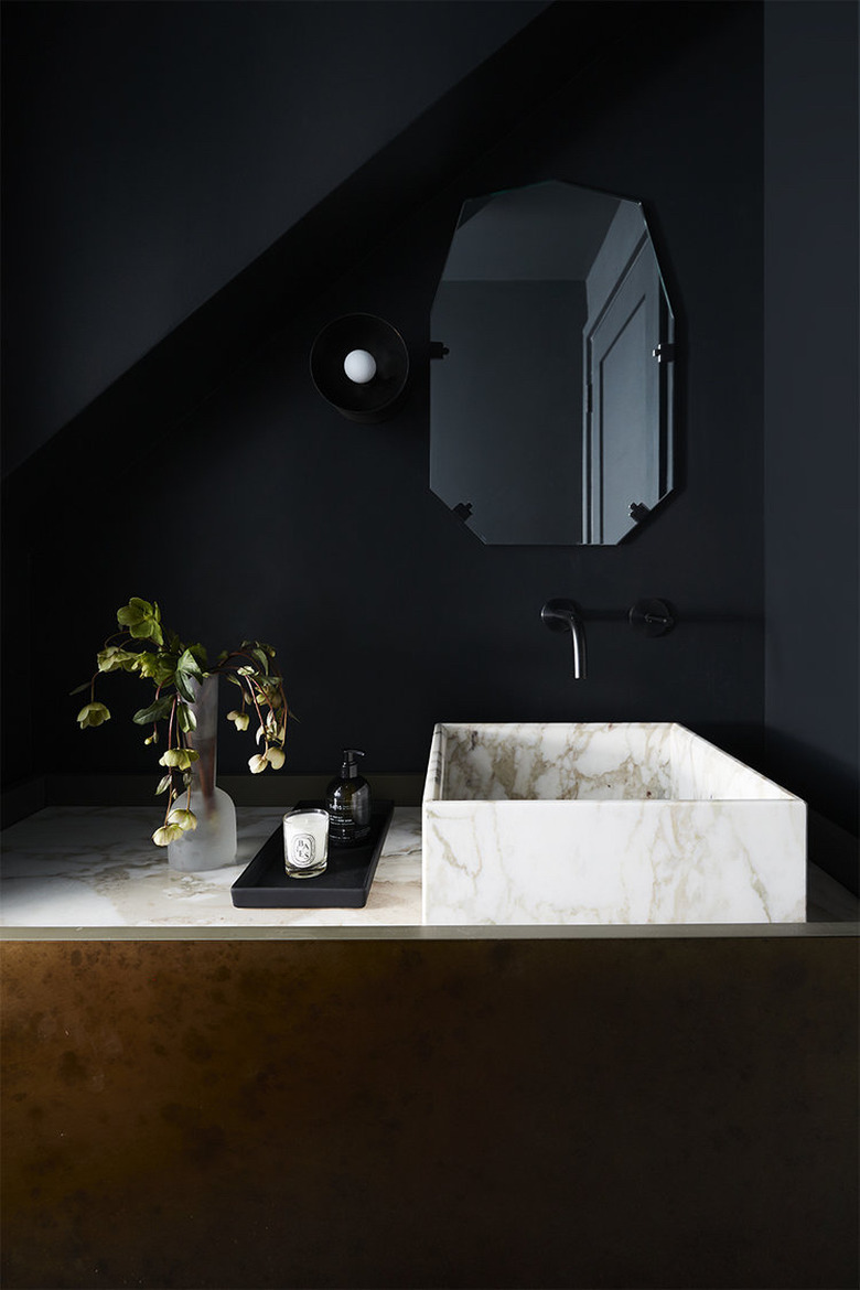 Black bathroom with marble vessel sink and countertop