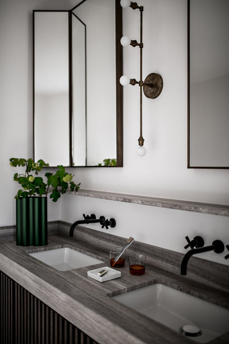 masculine bathroom with his and hers sinks and black wall mount faucets