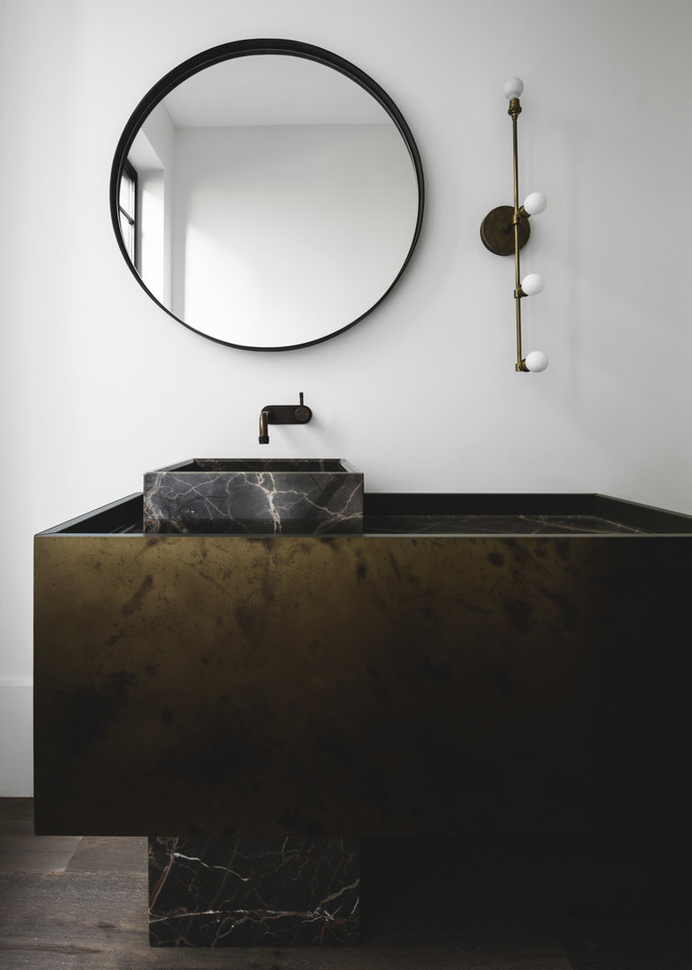 contemporary bathroom with black marble and metal vanity and wall mount faucet