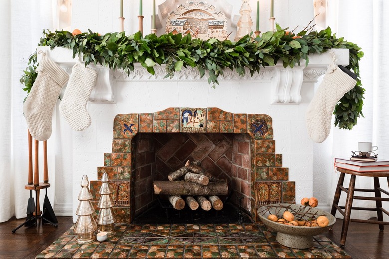 contemporary Christmas decor with vintage fireplace decorated with garland for christmas