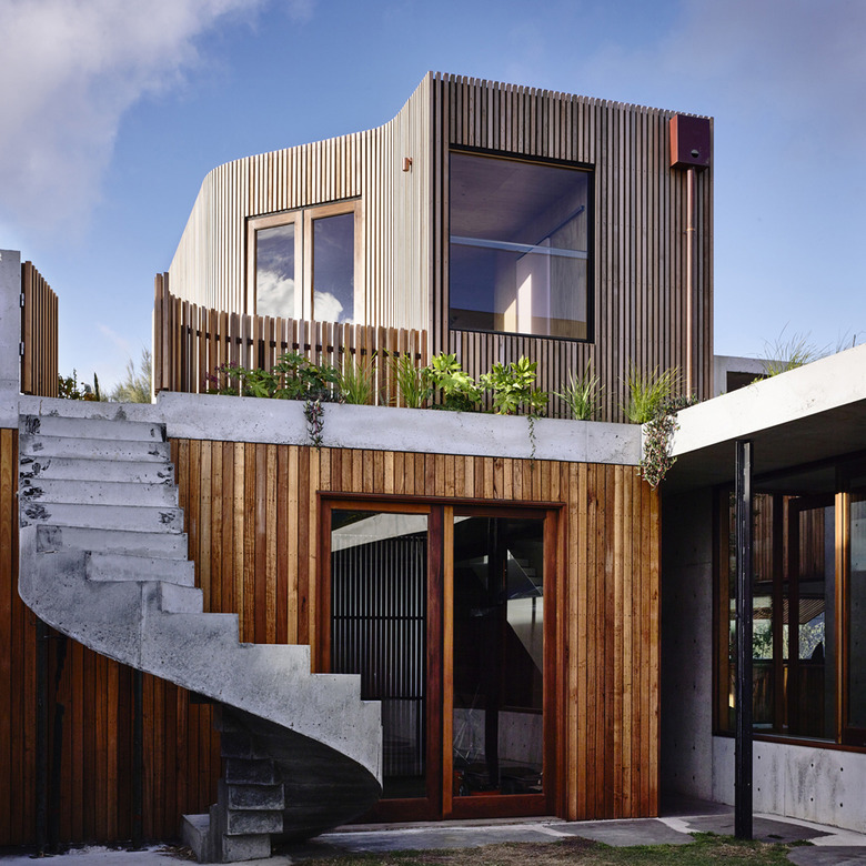 Contemporary home exterior with wood siding and winding staircase