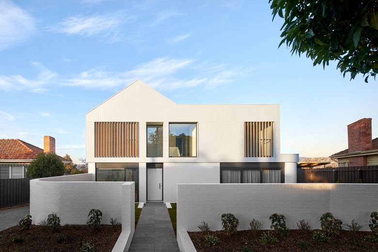 White contemporary home exterior with wood planks and minimalist features