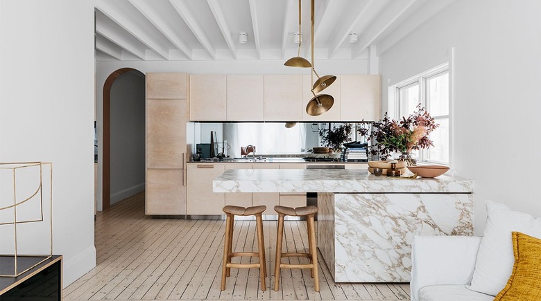 contemporary kitchen with marble island and light wood cabinets