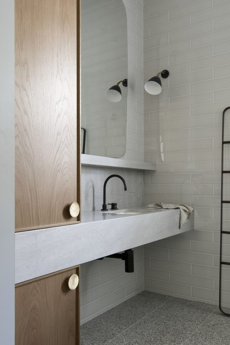 undermount bathroom sink in concrete countertop with gray walls and flooring