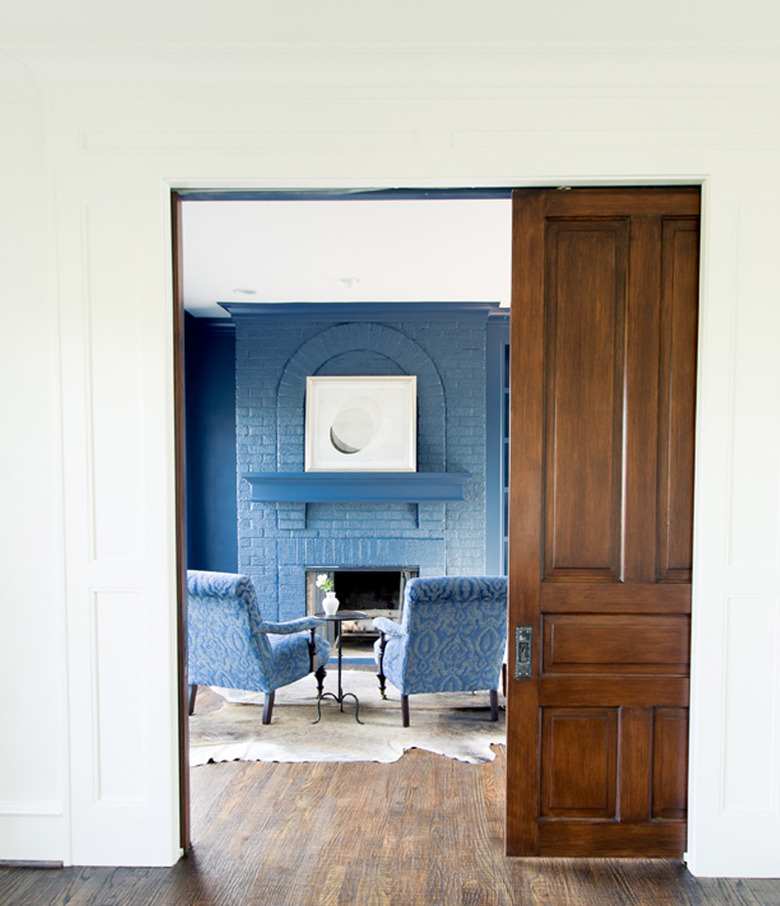 cornflower blue library with fire place and chairs in cool colors