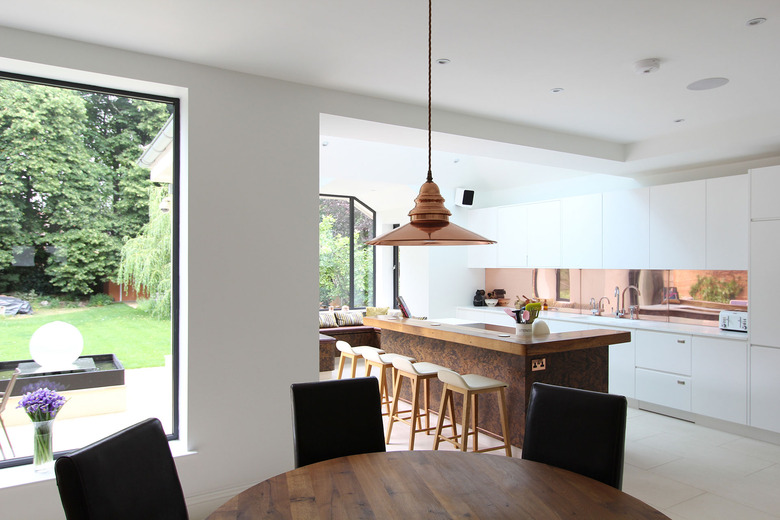 white kitchen with copper backsplash and large island