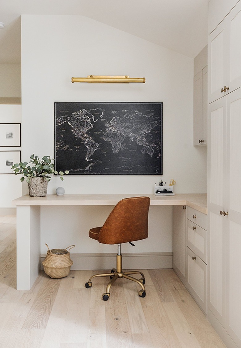 corner home office with built-in desk and leather office chair