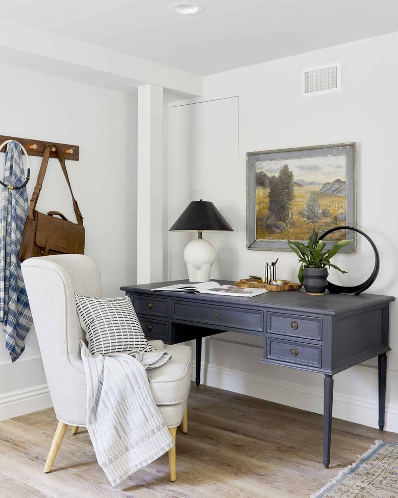 corner home office with vintage blue desk and upholstered office chair