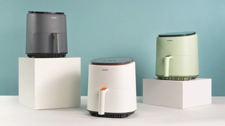 Cosori air fryers with different colors: green, white, and gray