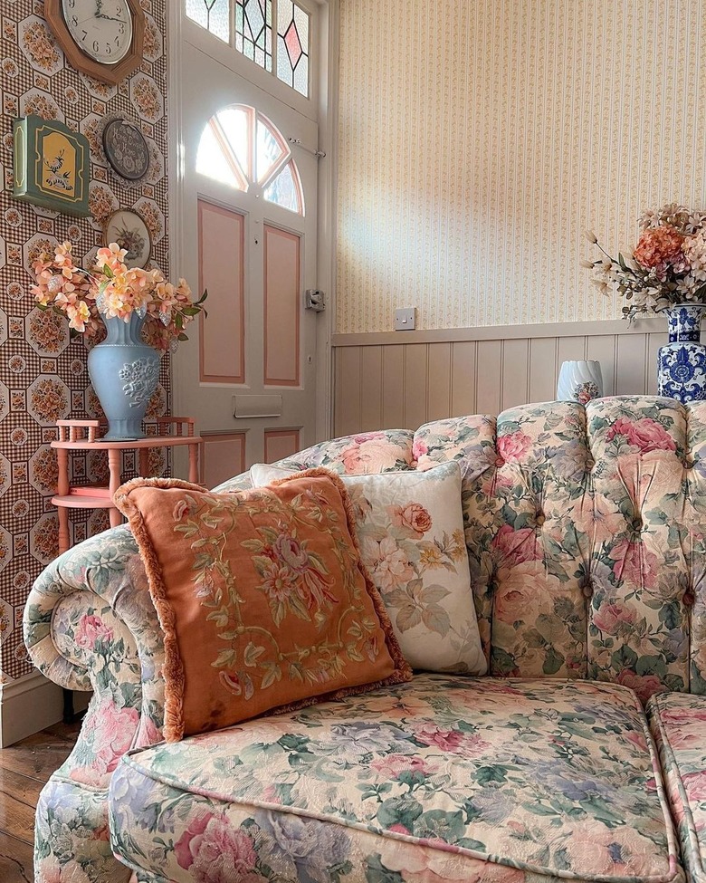 living room with floral sofa and wallpaper