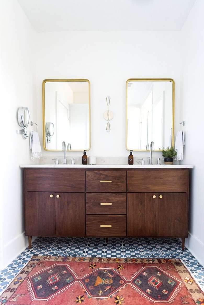 wood vanity with blue floor tiles and red runner