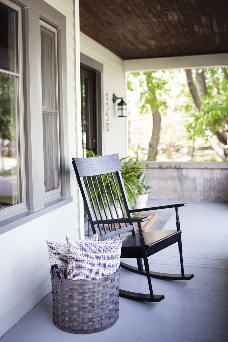 Craftsman front porch with black rocking chair and basket with pillows