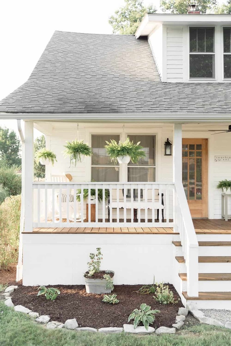 Craftsman front porch with farmhouse details and hanging ferns