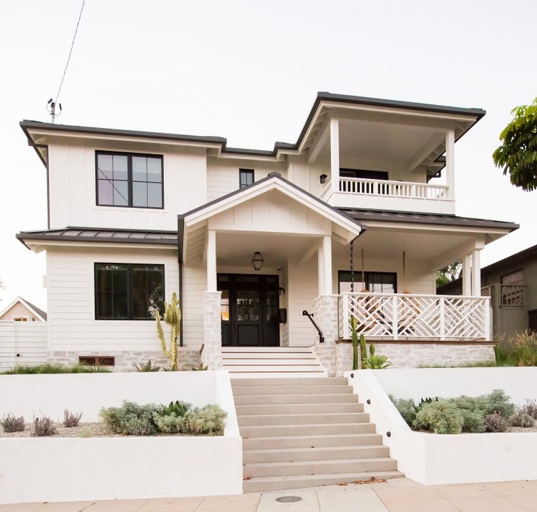 black Craftsman style door paired with white siding and black trim