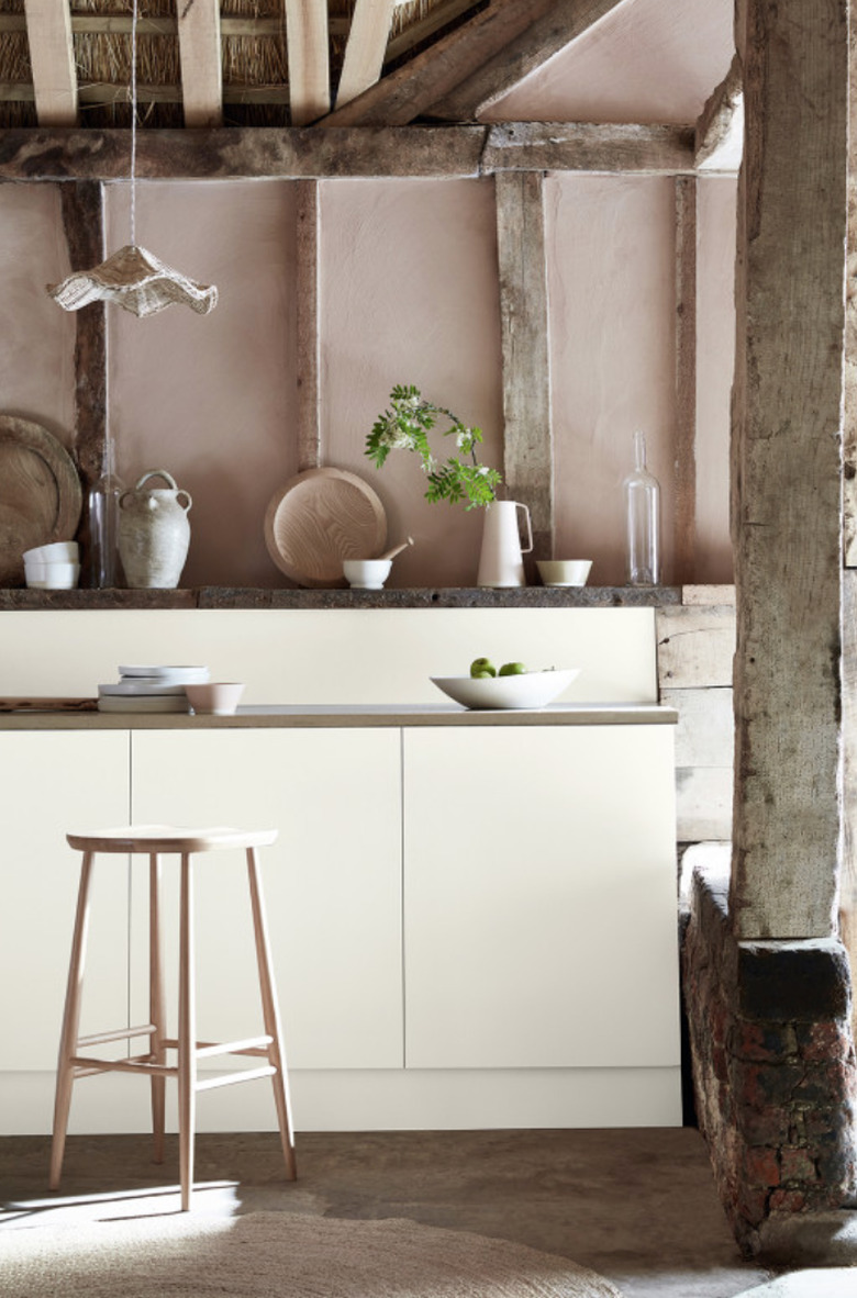 Rustic kitchen with wood beams and cream colored cabinets.