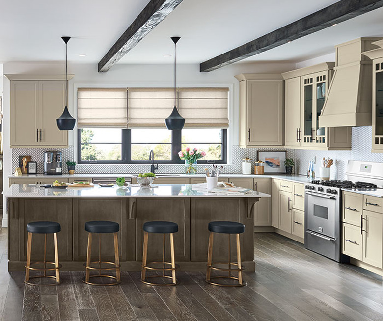 Cream kitchen with contrasting wood floor and island, plus barstool seating.