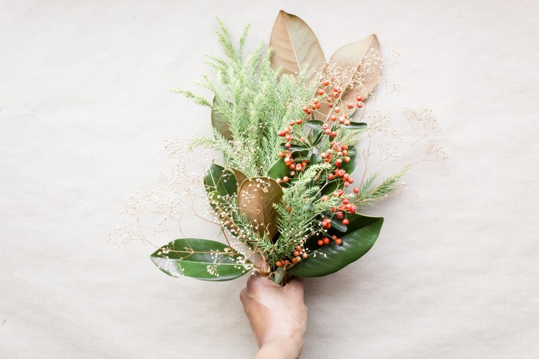 Hand holding winter-themed foliage bouquet