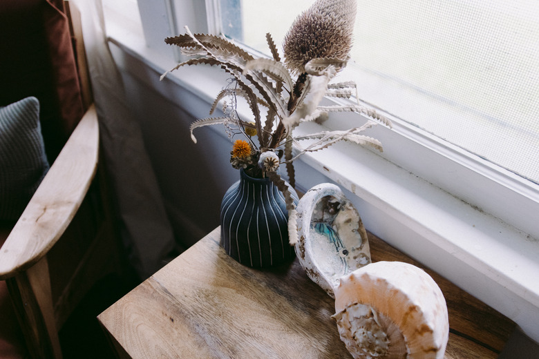 Dried floral arrangement next to window.