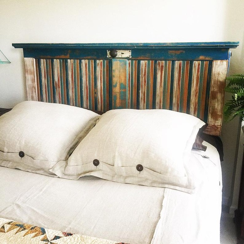 Multicolor louvered door as headboard with white beddings