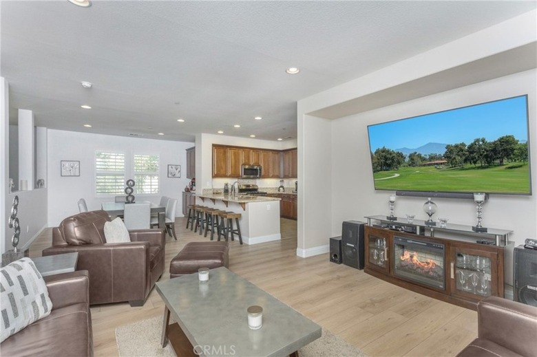 Living room with TV that leads into an open area kitchen