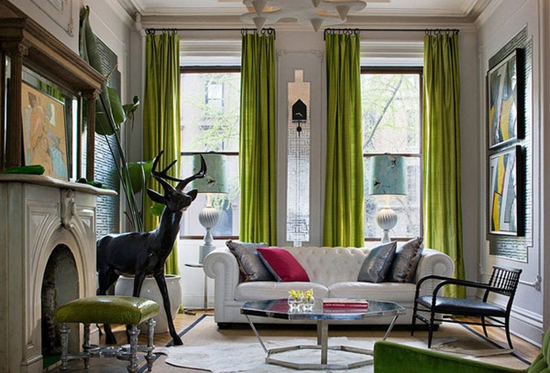 Living room with lime green curtains, white curtains and a fireplace.