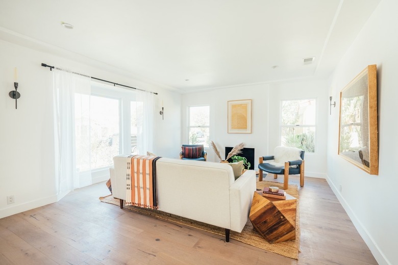 A living room with sheer curtains on the French doors