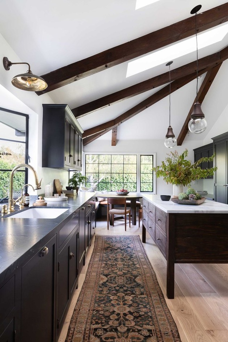 dark kitchen cabinets with light floors and a patterned kitchen runner