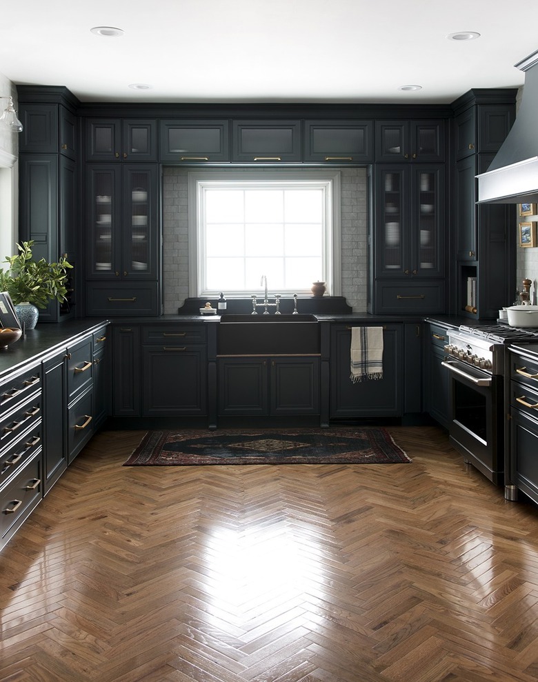 traditional kitchen with dark kitchen cabinets with light floors in herringbone pattern