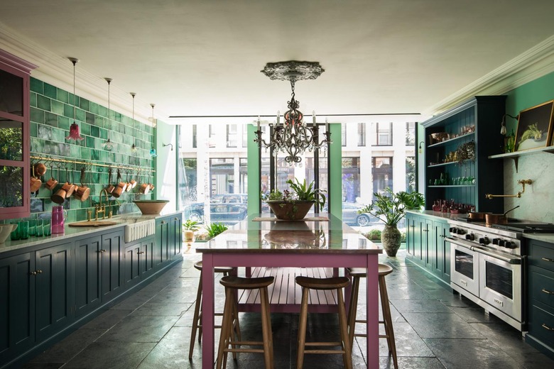 colorful tiled backsplash with stainless steel appliances and dark kitchen floors of polished square tiles