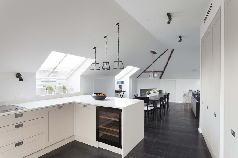 loft style space with sconces and polished wood dark kitchen floors