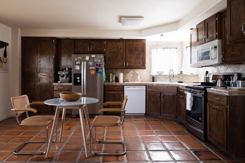 dark kitchen floors with polished terra cotta tile and wood cabinets