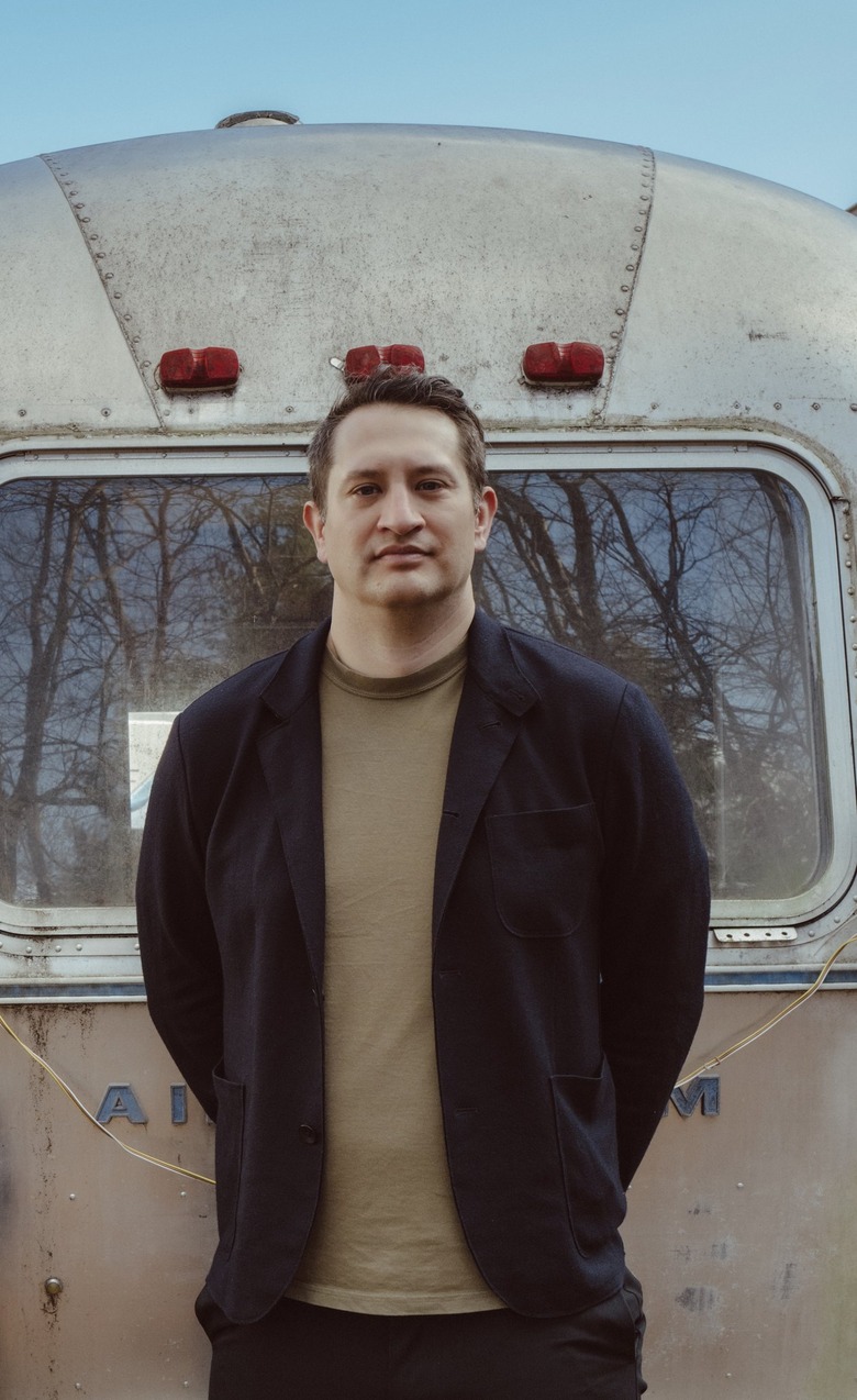 Jeffrey Mansfield, a white person with short brown hair, standing in front of a gray Airstream trailer.