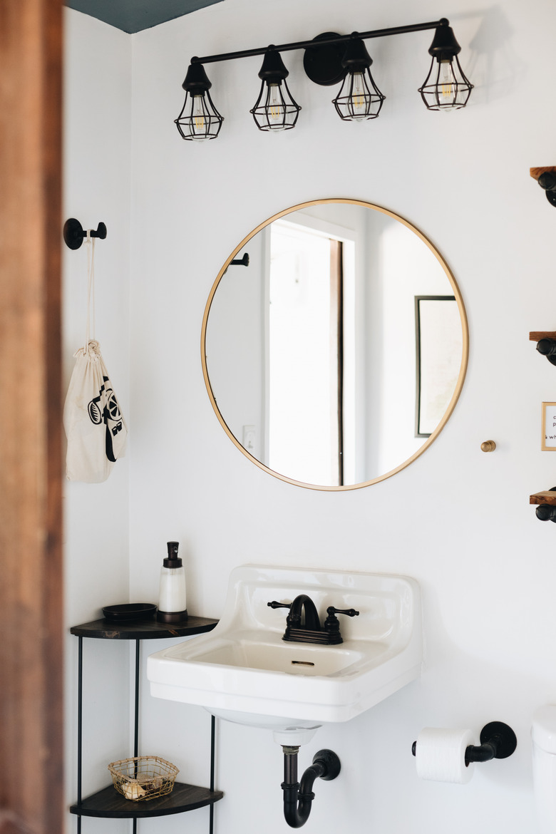 black and white bathroom with wall mount sink and matte black deck-mounted faucet