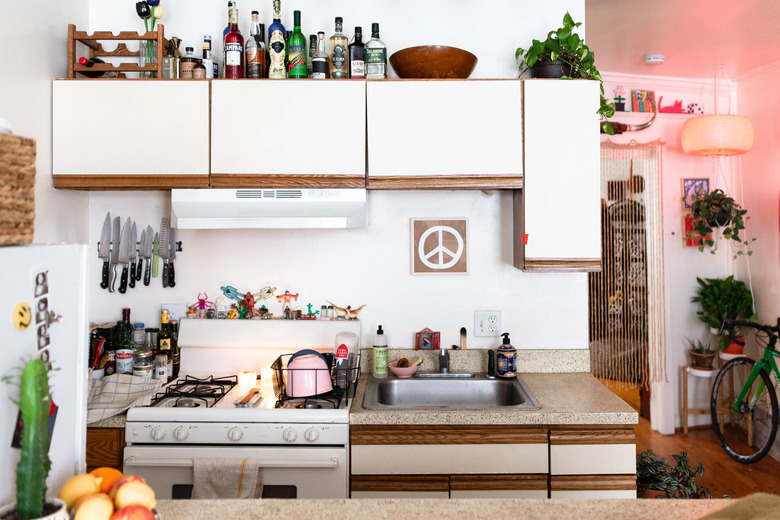 kitchen with white cabinets and liquor  bottles atop them