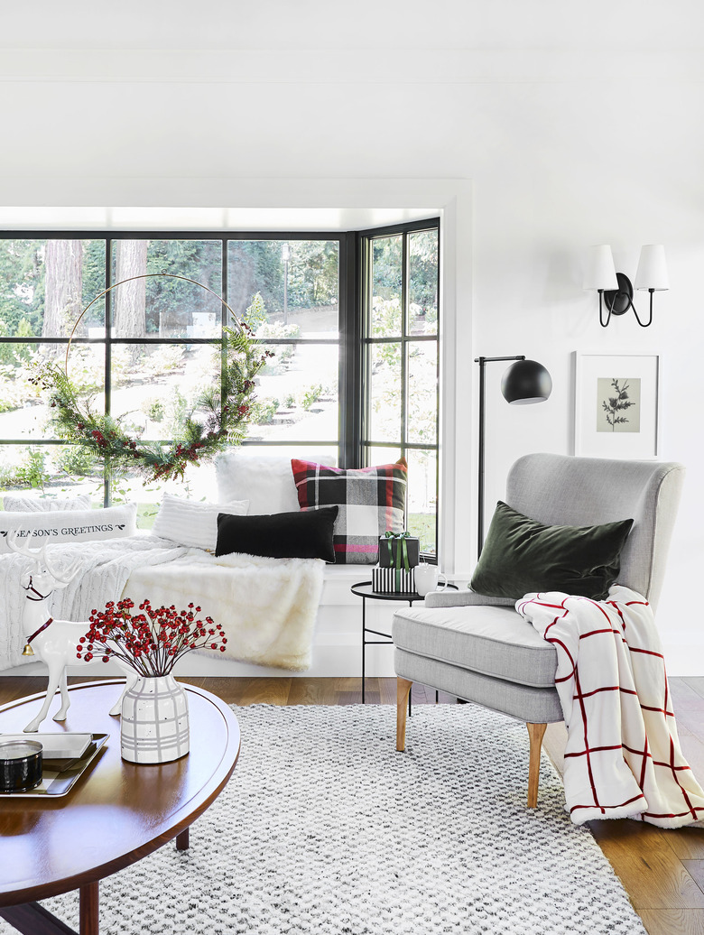 festive living room decorated for the holidays with a large wreath and plaid decor accents