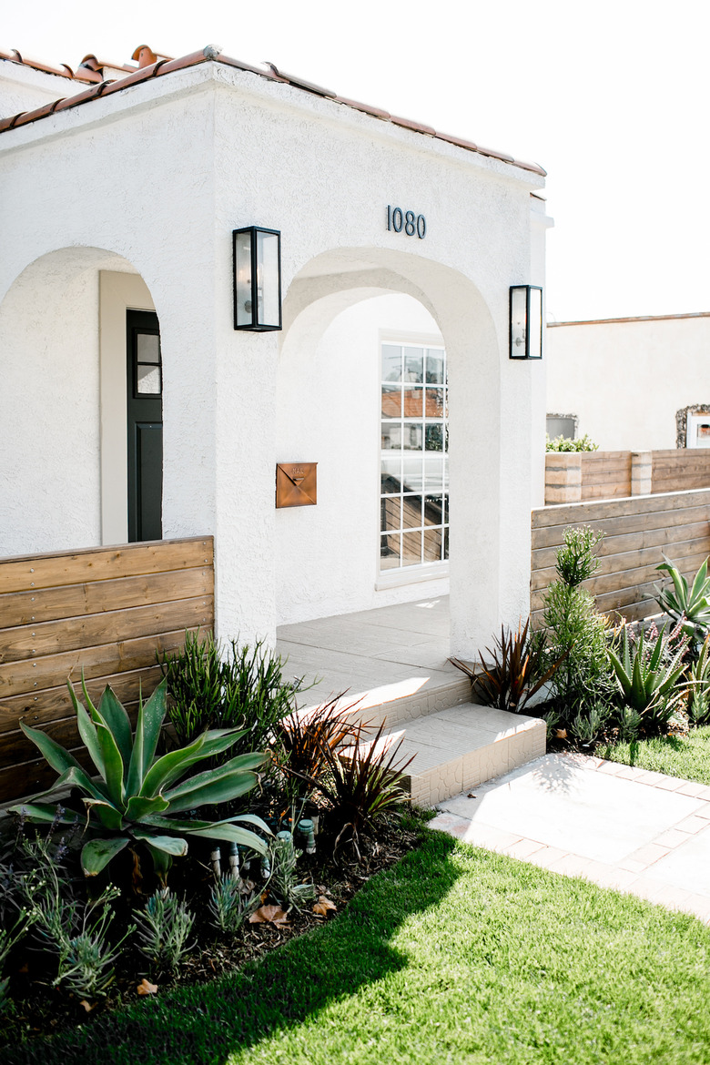 Desert style home with white exterior and terra cotta roof