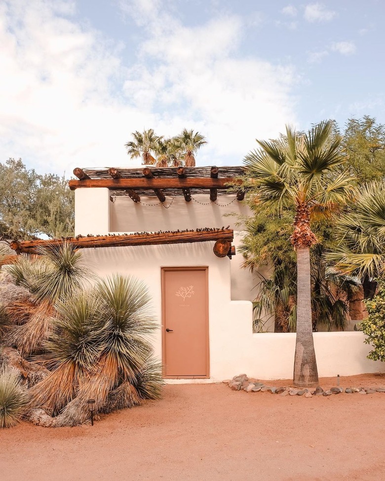 Desert style home in the adobe style with palm trees and exposed timbers